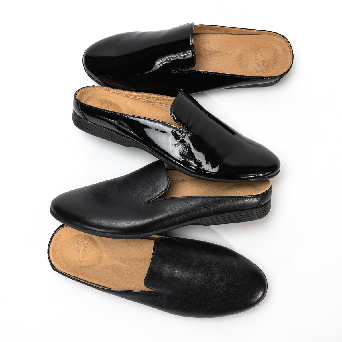 Group photo of black leather and patent leather Dansko Lexie mules. A classic and sleek slip-on leather shoe. 