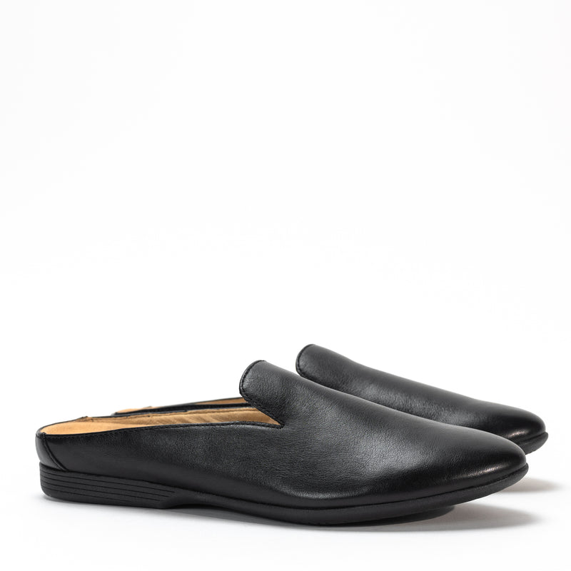 Side view of Dansko Lexie mule in black smooth leather, highlighting sleek design and low heel.