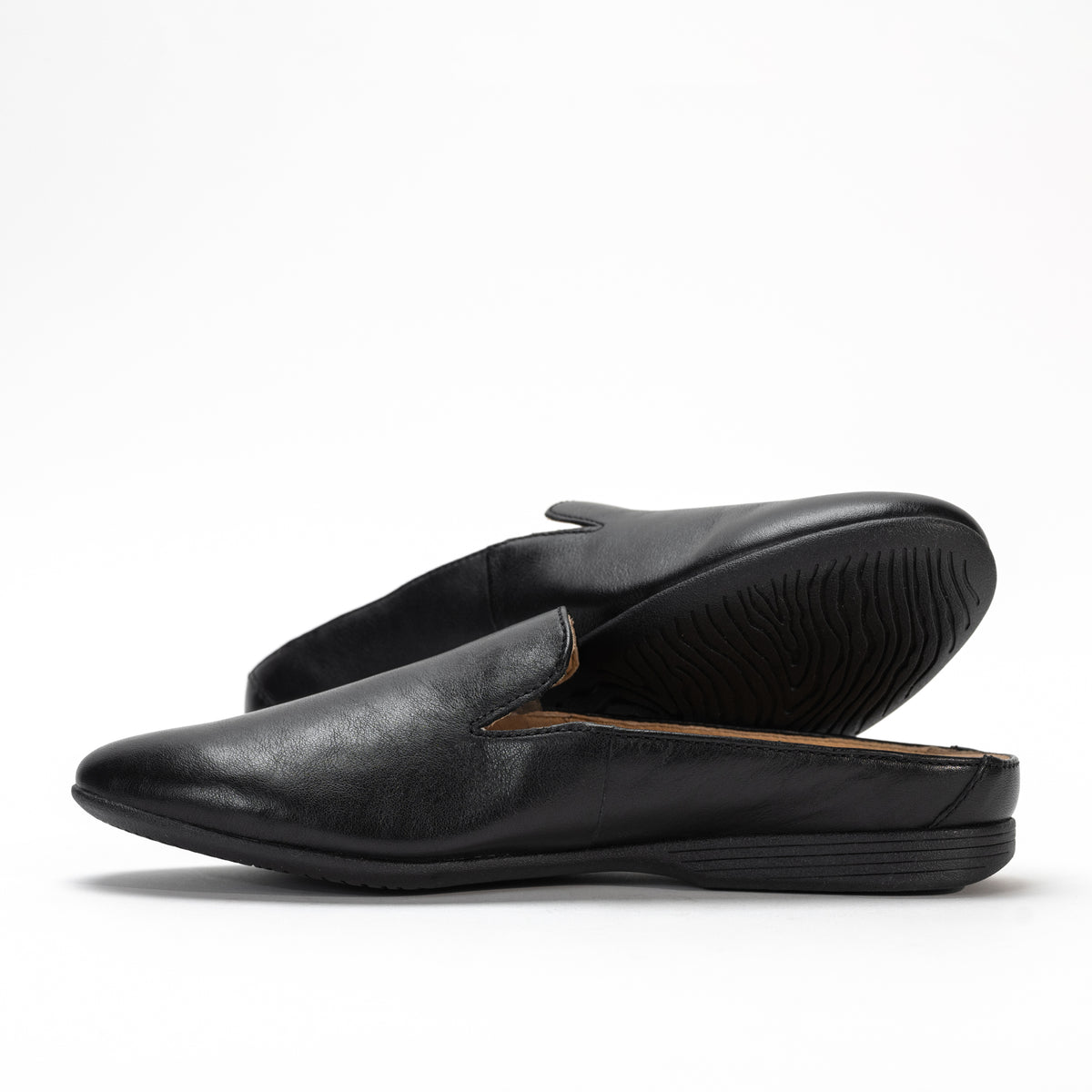 Side view of Dansko Lexie mule in black smooth leather, highlighting sleek design and low heel.