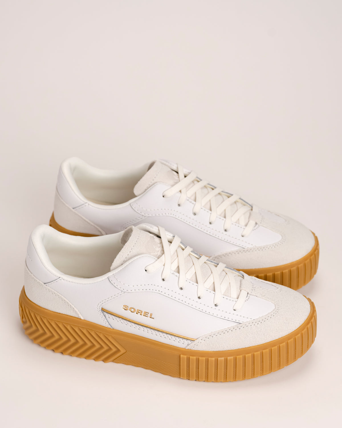 Pair of Women’s SOREL Ona Ave T-Toe platform sneakers in Sea Salt / Gum 17 on white background.