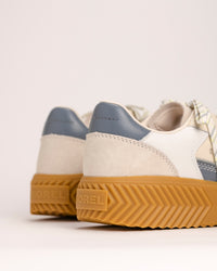 Pair of SOREL Ona Ave T-Toe sneakers with a focus on the platform sole and SOREL logo against a light background