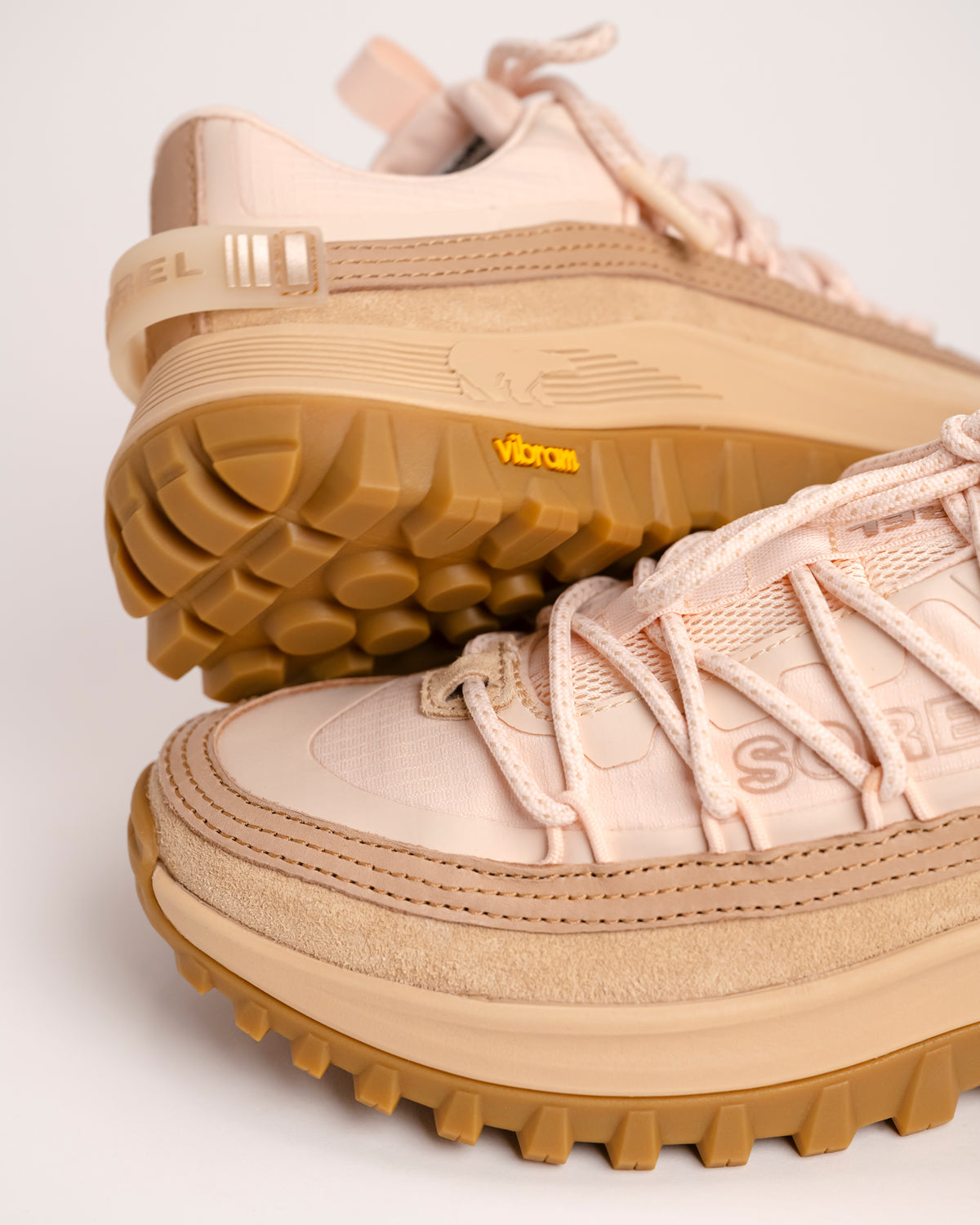 Toe and heel detail view of a pair of SOREL Callsign Horizon™ Low hiking shoes with brown Vibram soles on a light background