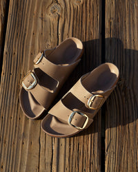 Outdoor shot of the Birkenstock Arizona Big Buckle Sandal in Tobacco Brown Oiled Leather on a wooden background