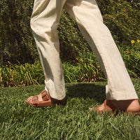 Lifestyle image of a male wearing the Birkenstock Arizona sandal in Cognac Oiled Leather in a spring outfit.