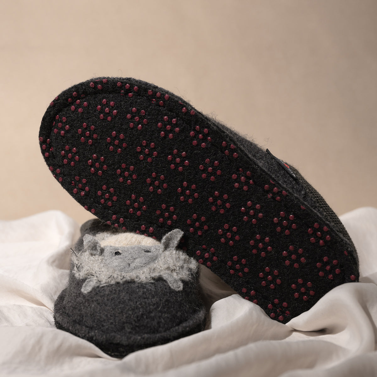 Detail view of the latex anti-slip dots on the bottom of the Women's Haflinger Lamby Soft and Cozy Wool Slipper in Gray.