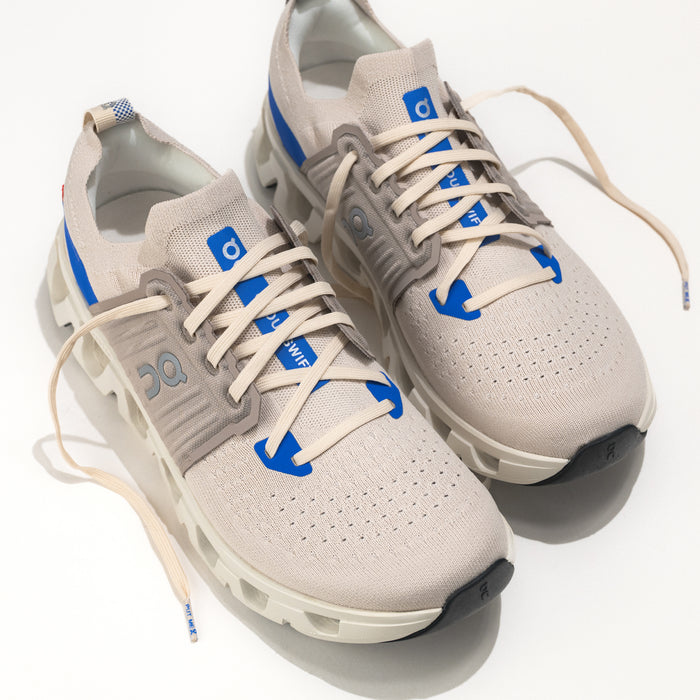Pair of beige sneakers with blue accents on a white background.
Men's On Running Cloudswift 4 Road Running Shoe in Cream/Cobalt