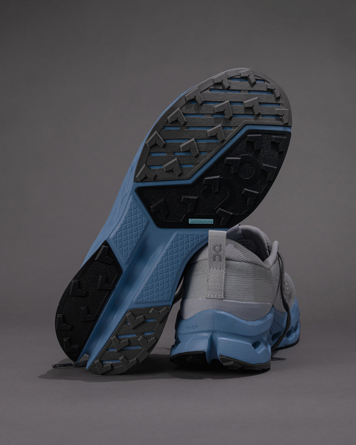 Gray and blue athletic shoe with sole detail on a gray background
Men's On Cloudsurfer Trail 2 in Rock/Niagara – Plush Cushioning Trail Running Shoe