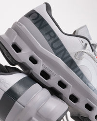 Rear side view of Men’s On Cloudmonster 1 Glacier/Alloy showing structured cushioning and support