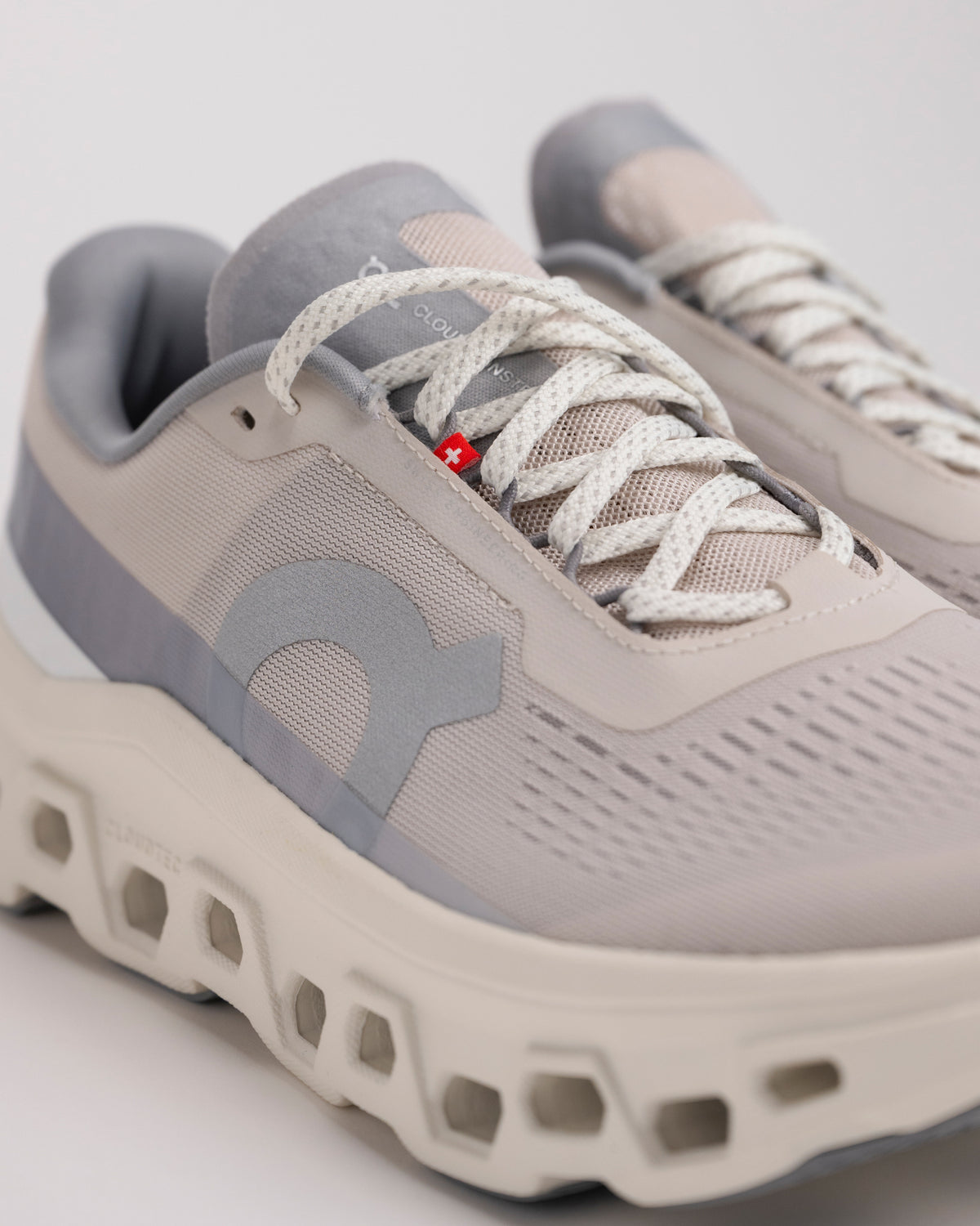 Upper detail view of Men’s On Cloudmonster 1 Pearl/Ivory with breathable mesh upper and hidden eyelets