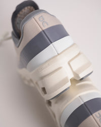 Heel view of Men’s On Cloudmonster 1 Pearl/Ivory showing structured cushioning and support