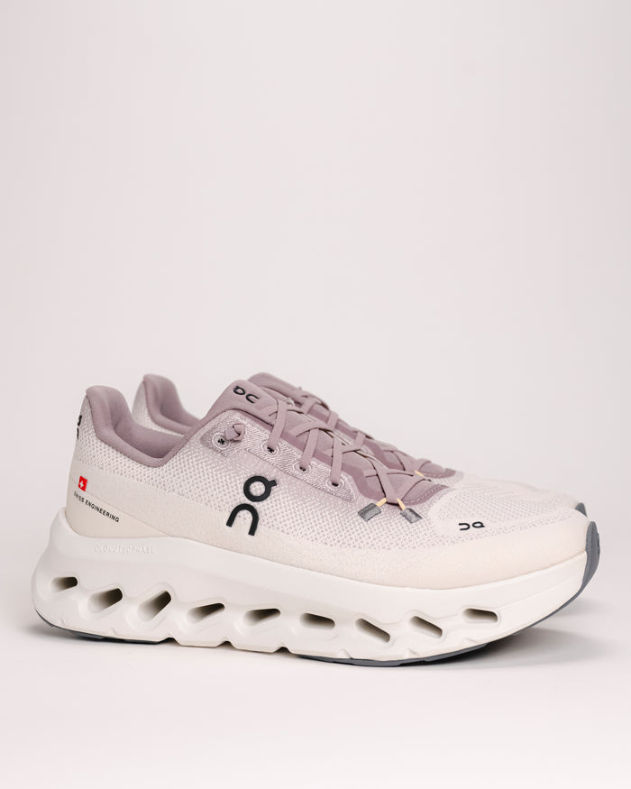 Side view of the women’s On Cloudtilt – Cushioned Lifestyle Sneaker in Heron / Dew, white and light purple, sneaker with a visible "On" brand logo on a light background