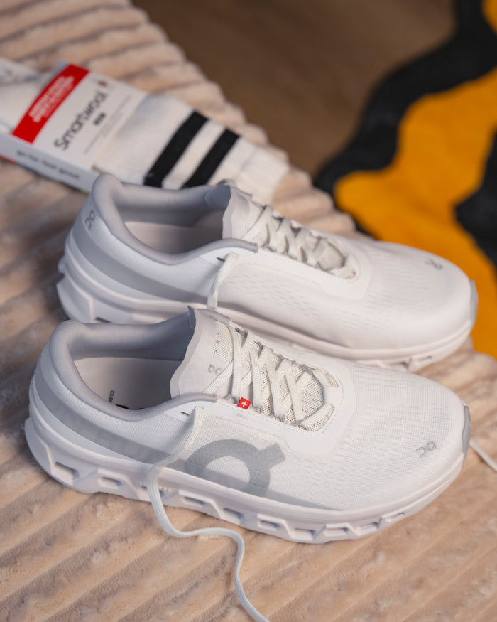 Top‑down view showing mesh upper and plush sockliner of On Cloudmonster 1 women’s runner with Smartwool sock