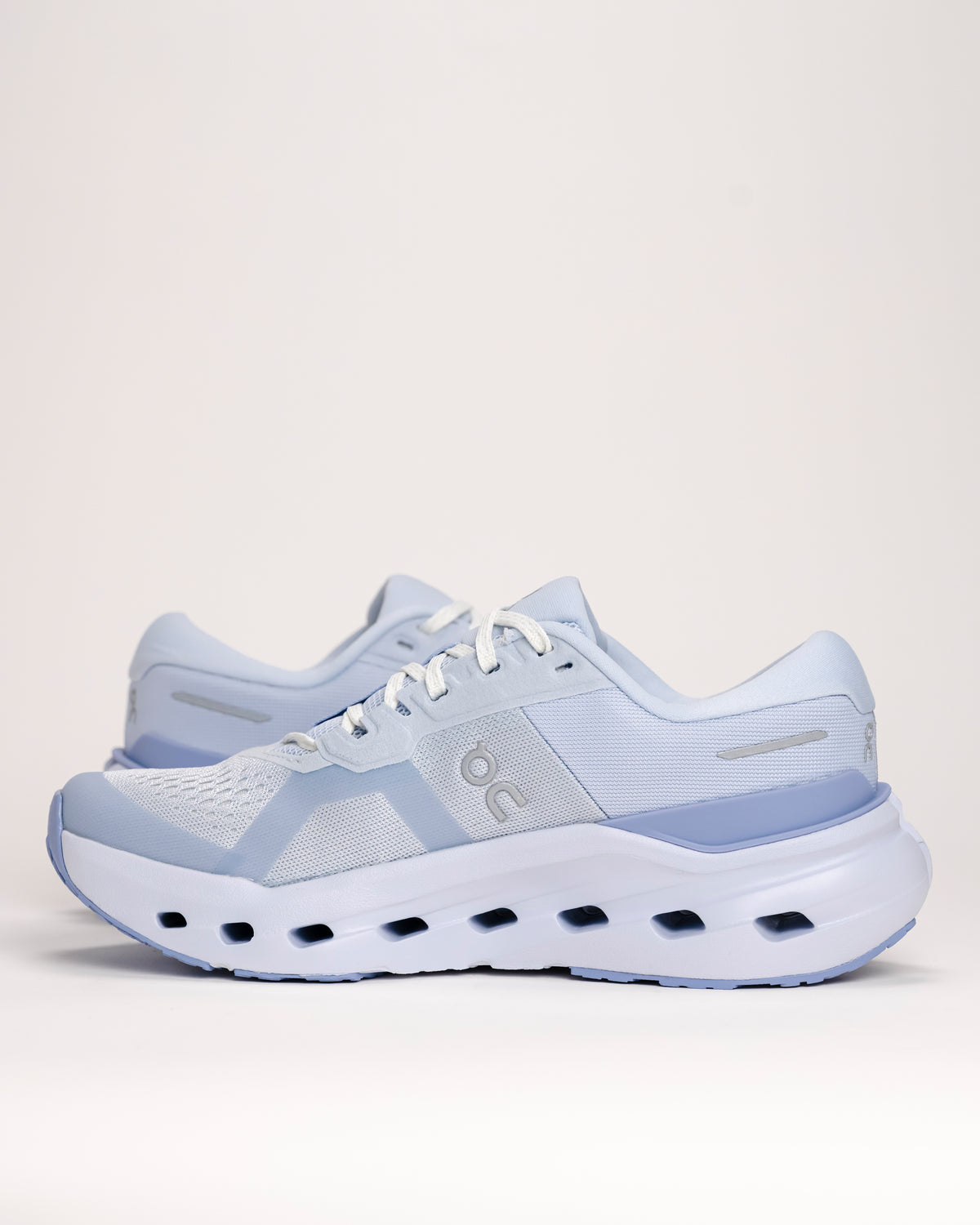 Light blue On running shoes on a white background focusing on the upper and midsole details