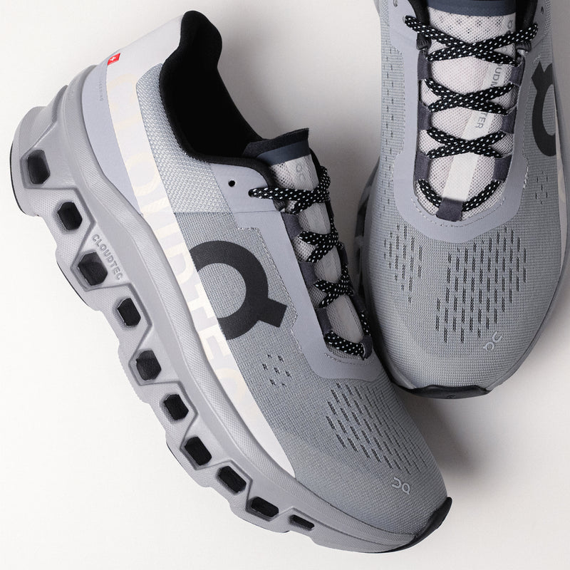 On Running Cloudmonster midsole detail, emphasizing Helion™ superfoam and Speedboard® technology.