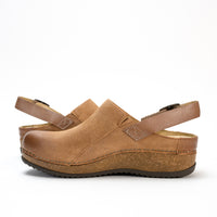 Side profile of the Dansko Merrin mule in high-quality leather, featuring a sleek sling-back strap and cork midsole.