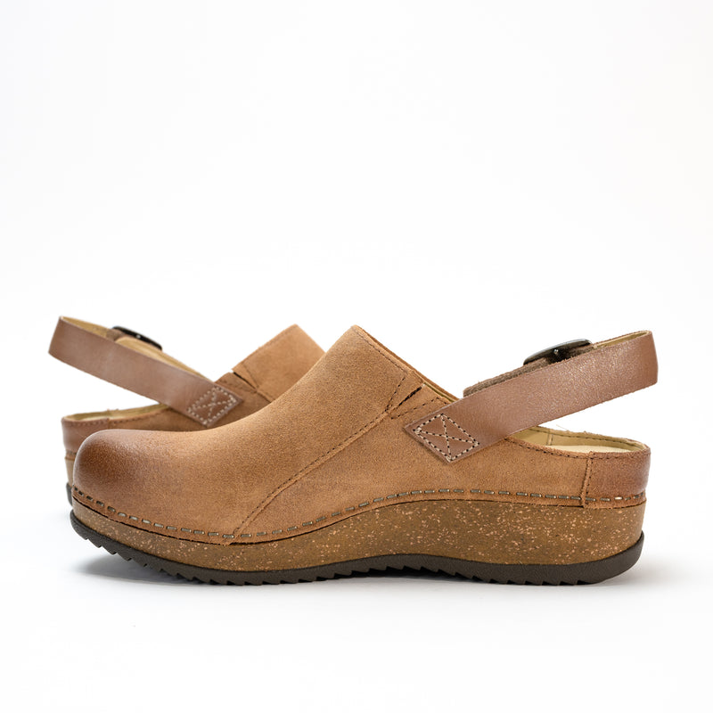 Side profile of the Dansko Merrin mule in high-quality leather, featuring a sleek sling-back strap and cork midsole.