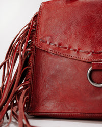 Front view of Hidden bag with magnetic flap closed highlighting leather stitching and fringe detail.
