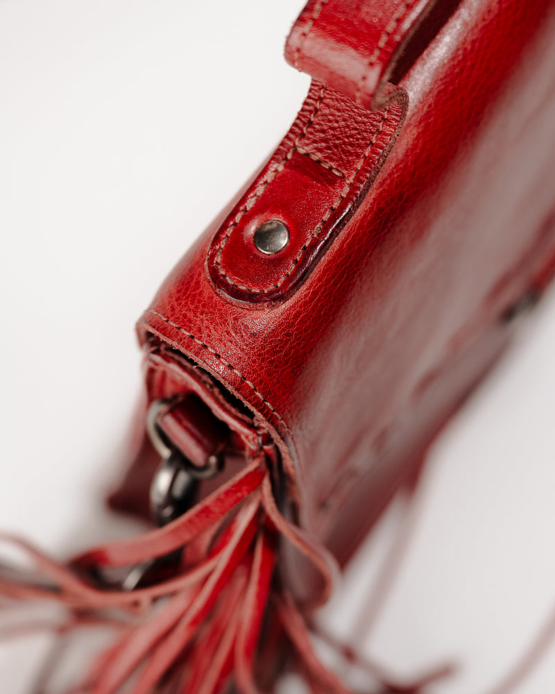 Detail view of the Hidden crossbody bag showing top handle and rivet stitching.