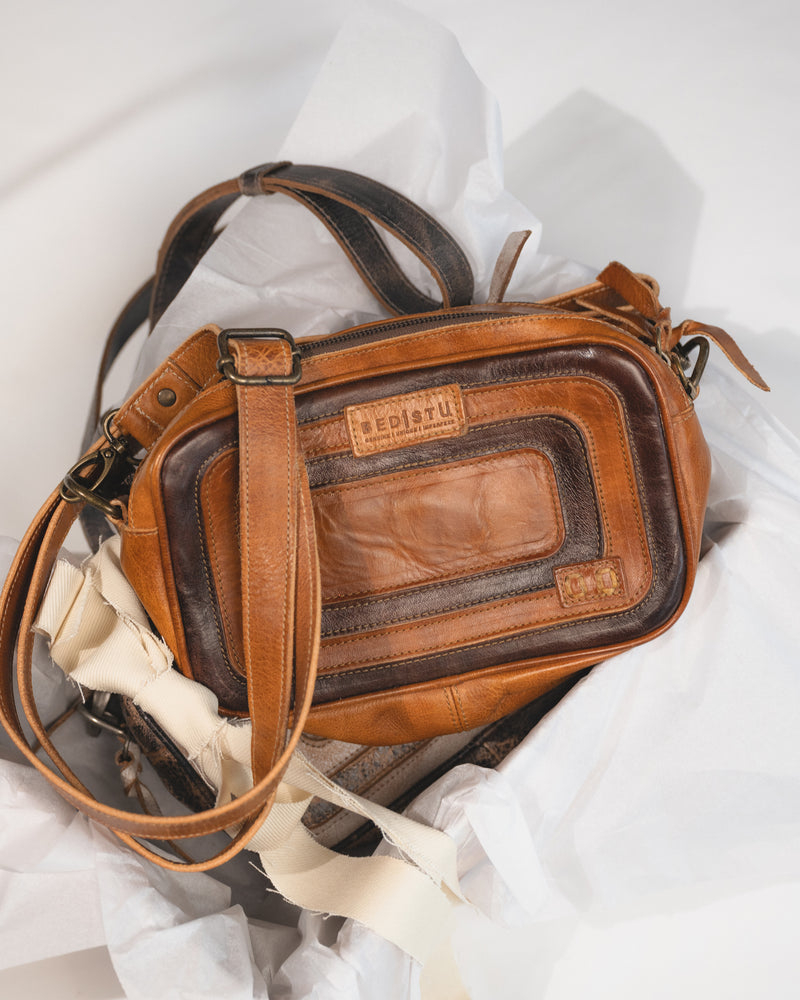 Front view of Bed|Stü Shy compact leather crossbody bag showing rectangular shape and leather overlays in a gift box