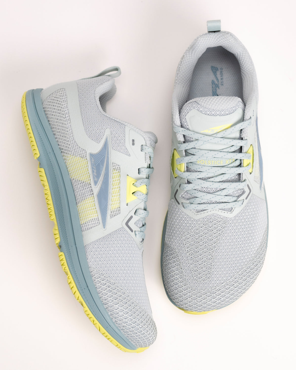 Pair of women’s Altra Solstice XT3 gray running shoes with bright yellow accents on a light background