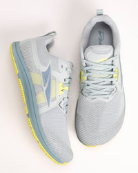 Pair of women’s Altra Solstice XT3 gray running shoes with bright yellow accents on a light background