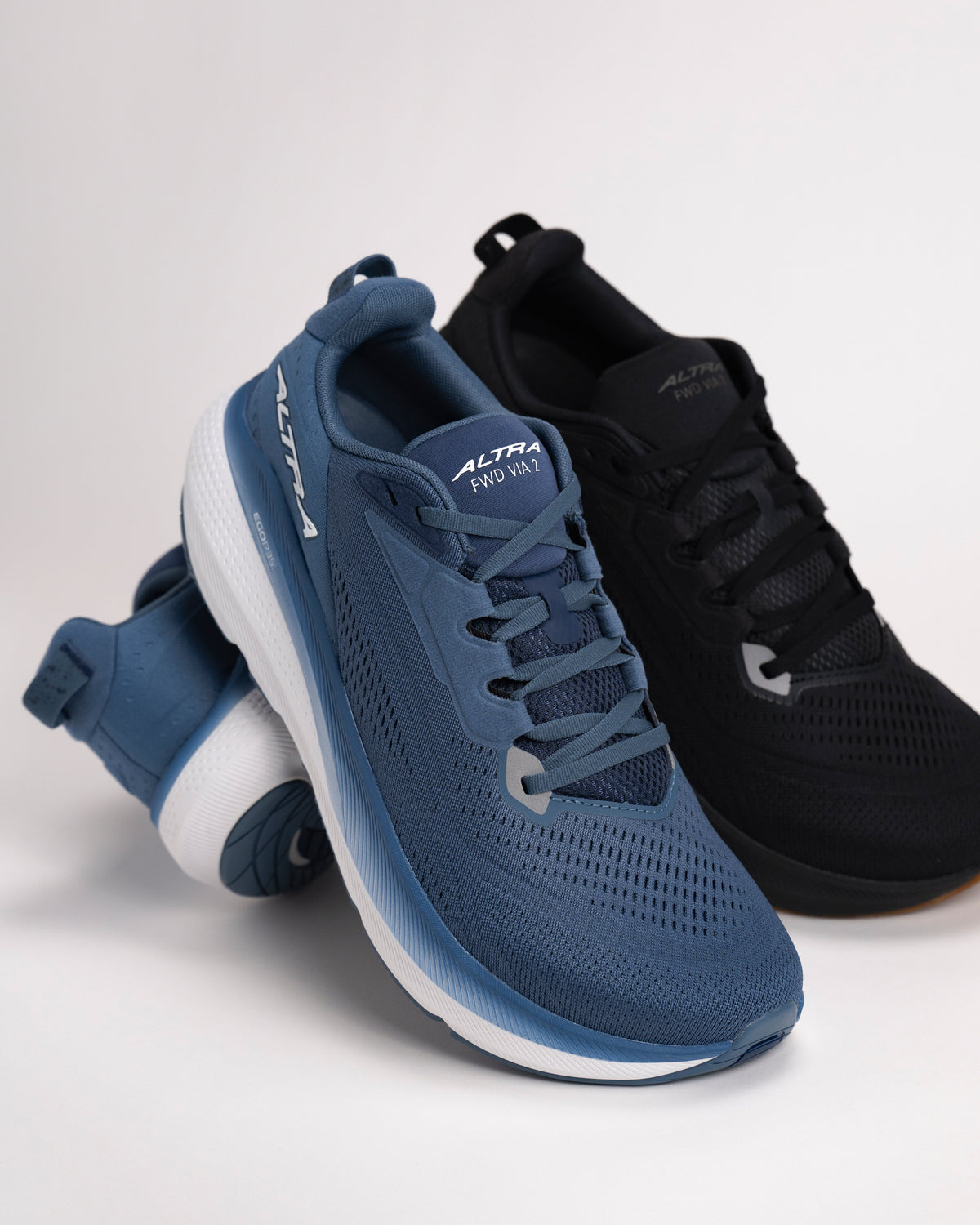 Group of navy and all black FWD VIA 2 road running shoes on a light background