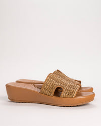 L’Amour Des Pieds Catian Slide sandal in brown woven raffia on white background.