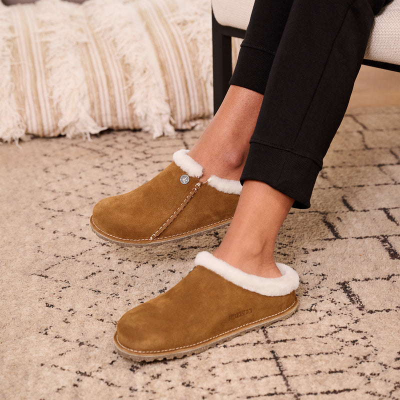 Close-up of woman’s feet in cozy Birkenstock Zermatt shearling slippers, showcasing soft suede and comfort footbed.