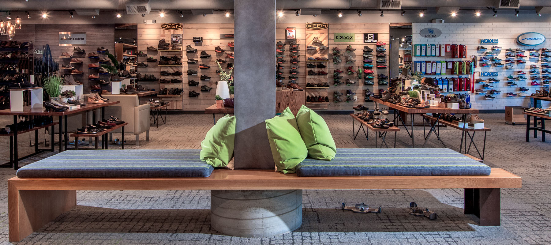 Interior of Plaza Shoe Store showcasing mid-century modern design elements, with natural wood accents, concrete and metal finishes, and vibrant pops of color, creating a warm and inviting shopping environment.