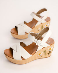 The Ava 2.0 in White / Cream with Floral Embroidery is a modernized tribute to the legendary 1970s "Buffalo Sandal" that put Kork-Ease on the fashion map. This specific edition pairs smooth, cream-colored leather straps with a beautifully textured raffia-wrapped wedge, featuring delicate, multi-colored floral embroidery for a soft, bohemian touch. It’s a design that feels both nostalgic and fresh, offering a substantial platform look that doesn't feel heavy or clunky.