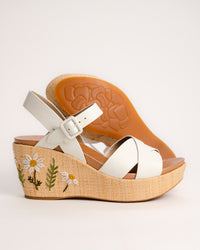 The Ava 2.0 in White / Cream with Floral Embroidery is a modernized tribute to the legendary 1970s "Buffalo Sandal" that put Kork-Ease on the fashion map. This specific edition pairs smooth, cream-colored leather straps with a beautifully textured raffia-wrapped wedge, featuring delicate, multi-colored floral embroidery for a soft, bohemian touch. It’s a design that feels both nostalgic and fresh, offering a substantial platform look that doesn't feel heavy or clunky.