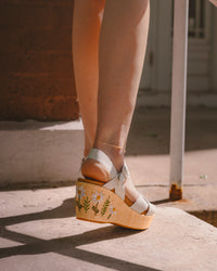 Women’s Kork-Ease Ava 2.0 Platform Wedge Sandal – Cream / White Raffia Wrap with Floral Embroidery - lifestyle image, summer sun