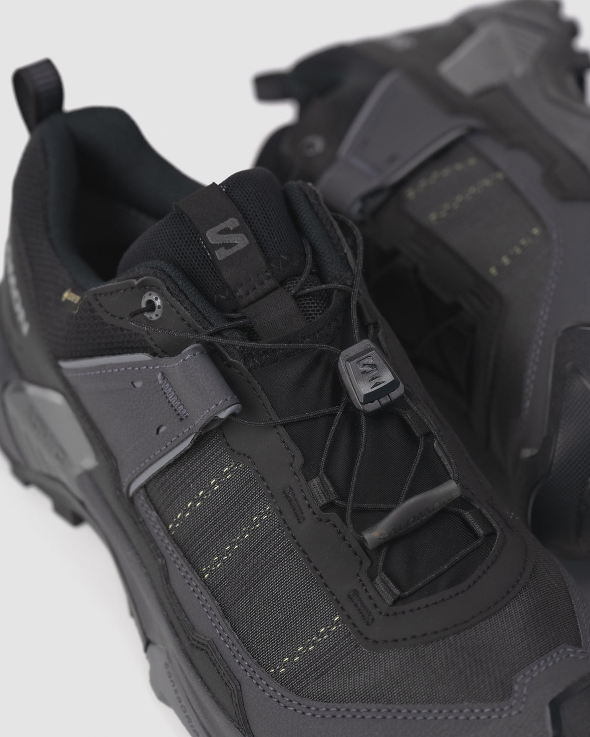 Detail view of Salomon X ULTRA 5 showing lace garage, "S" logo toggle, and padded collar