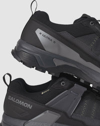 Side view of the Men’s Salomon X ULTRA 5 GTX showing pull tab, logo detailing, and mid-cut ankle support