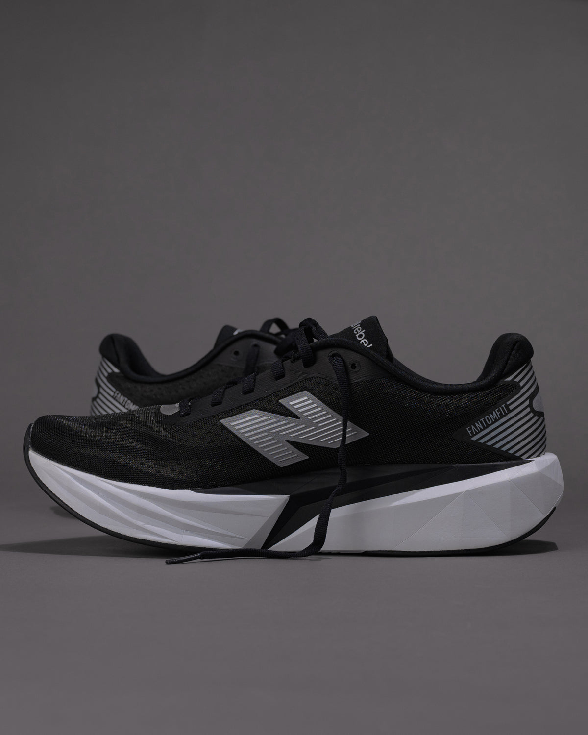 Black running shoes with white sole on a gray background
Men’s New Balance FuelCell Rebel v5 in Black/White – Lightweight Neutral Trainer
