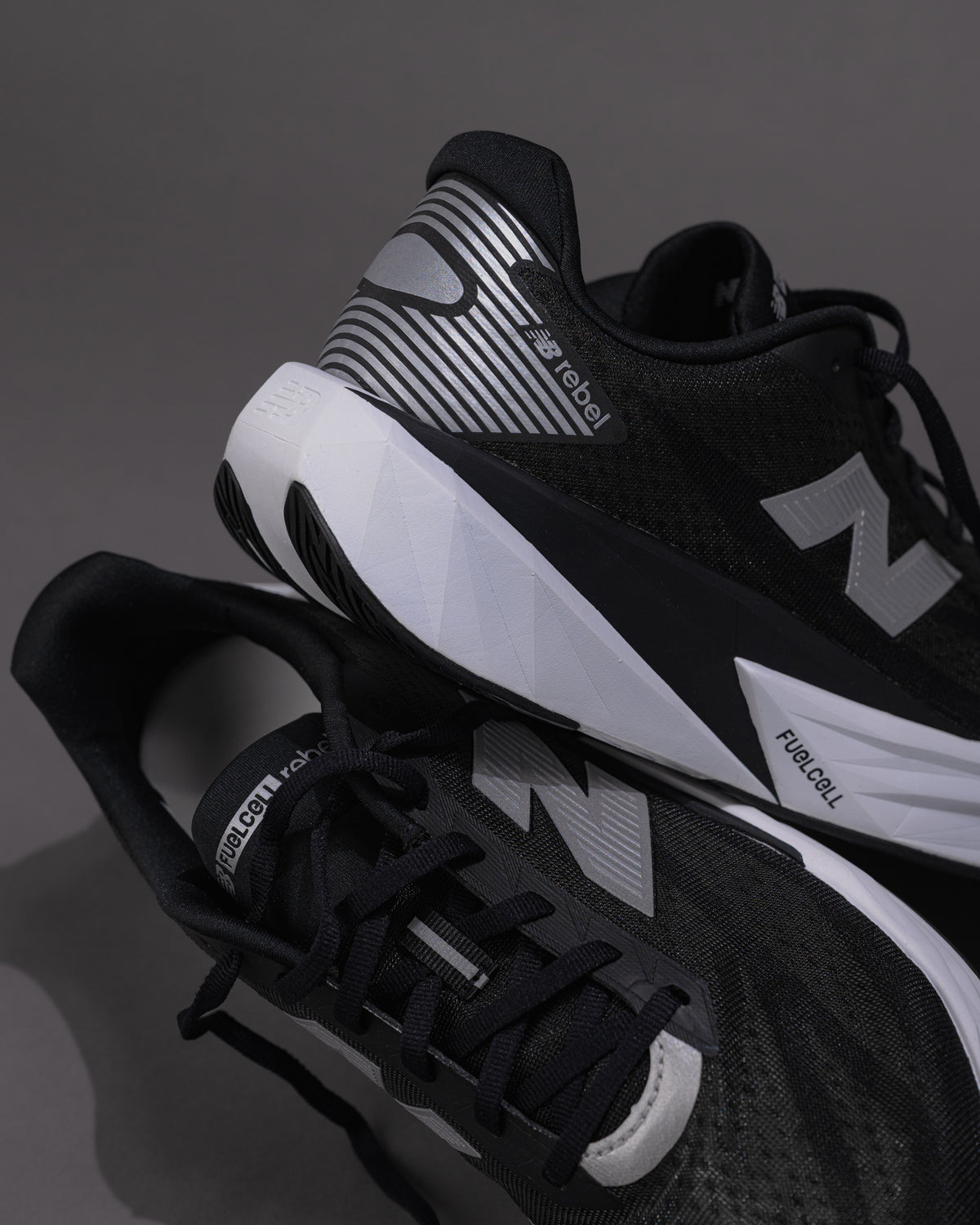 Black and white athletic shoes with visible branding on a dark background
Men’s New Balance FuelCell Rebel v5 in Black/White – Lightweight Neutral Trainer