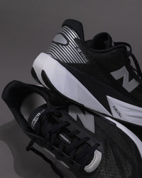Black and white athletic shoes with visible branding on a dark background
Men’s New Balance FuelCell Rebel v5 in Black/White – Lightweight Neutral Trainer