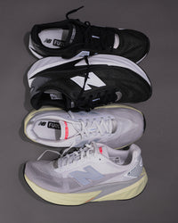 Two pairs of New Balance running shoes stacked on a gray background - FuelCell Rebel