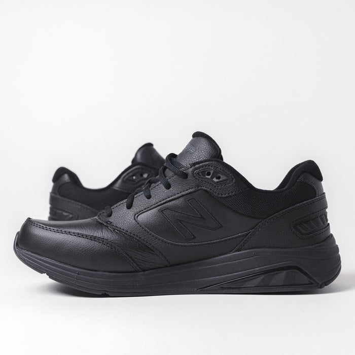 Side profile of the men's New Balance 928 V3 walking shoe in black leather.