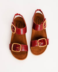 Red leather Taos On The Double sandals with cork sole on a white background