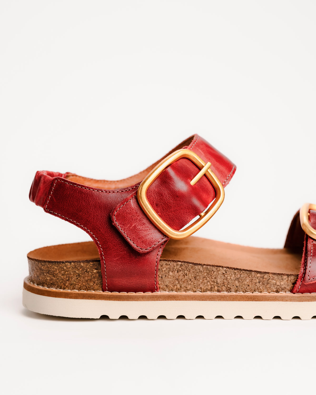 Red leather Taos On The Double sandals with cork sole on a white background