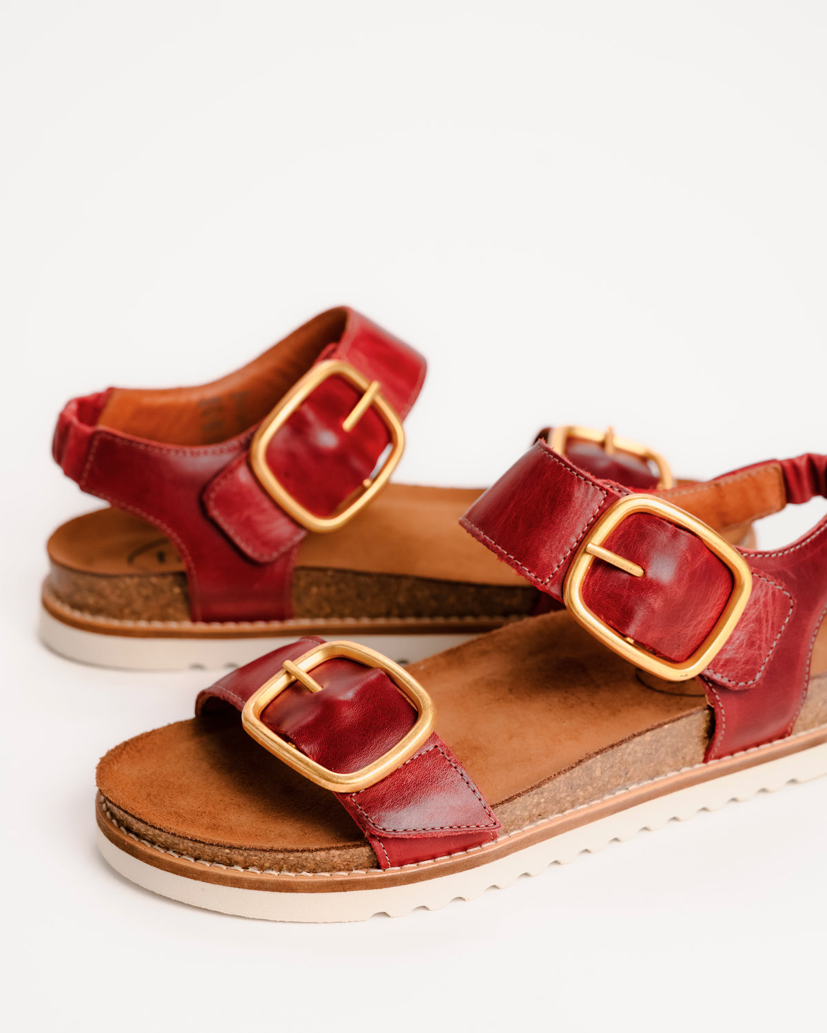 Red leather Taos On The Double sandals with cork sole on a white background