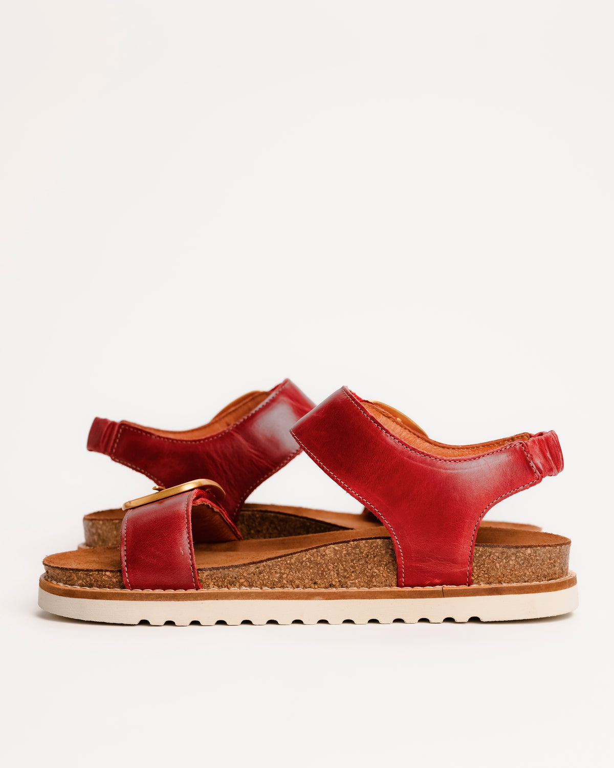 Red leather Taos On The Double sandals with cork sole on a white background