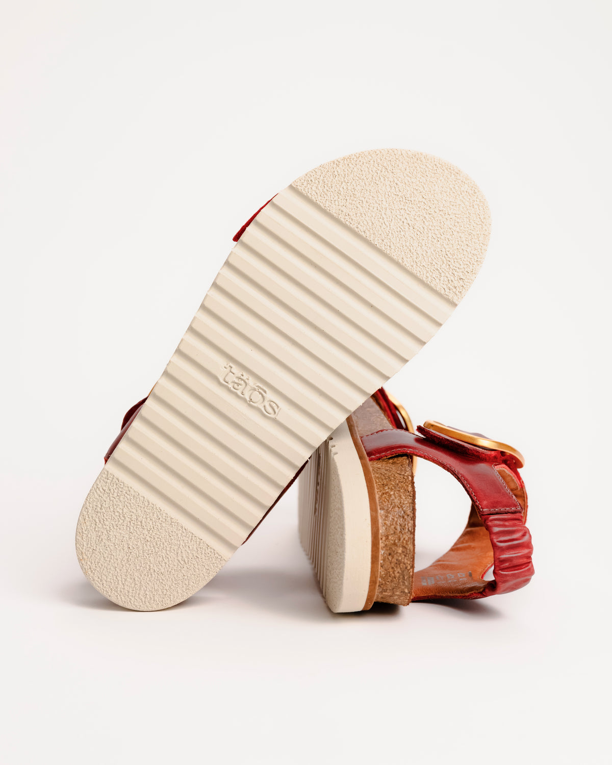 Red leather Taos On The Double sandals with cork sole on a white background