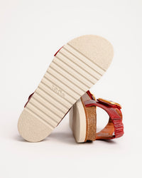 Red leather Taos On The Double sandals with cork sole on a white background
