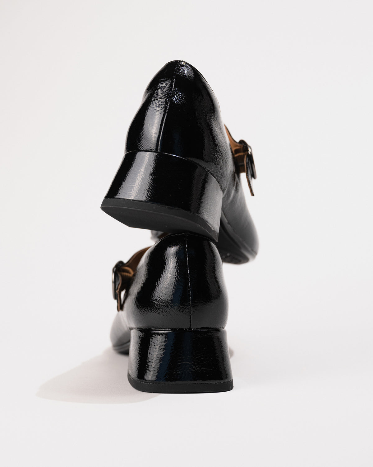 Close-up highlighting the wrapped blocky heel and glossy patent finish.
