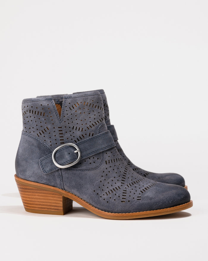 Blue suede ankle boot with a buckle on a white background
