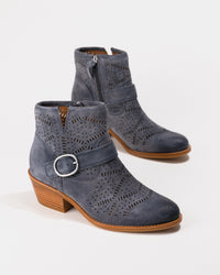 Pair of blue suede ankle boots with brown soles on a white background