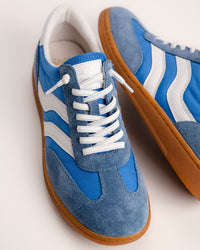 The Sofft Remmi in Blue is a fresh take on the classic retro runner, blending a vintage athletic silhouette with sophisticated, modern materials. Crafted from premium Italian suede with tonal nylon or fabric accents, this low-top sneaker features sporty contrast side stripes that give it an instant style refresh. It’s designed specifically for a lightweight feel, making it a go-to choice for transitioning your wardrobe into spring and summer.