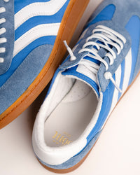The Sofft Remmi in Blue is a fresh take on the classic retro runner, blending a vintage athletic silhouette with sophisticated, modern materials. Crafted from premium Italian suede with tonal nylon or fabric accents, this low-top sneaker features sporty contrast side stripes that give it an instant style refresh. It’s designed specifically for a lightweight feel, making it a go-to choice for transitioning your wardrobe into spring and summer.